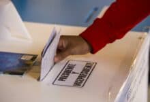 Un ciudadano emite su voto en la urna electoral blanca, con la etiqueta 'Presidente y VicePresidenta'